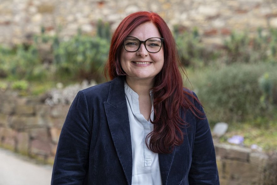 Pia Schellhammer, im Hintergrund eine Trockenmauer und bepflanztes Gelände Pia Schellhammer, im Hintergrund eine Trockenmauer und bepflanztes Gelände